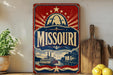 A vintage-style sign for Missouri featuring a steamboat and a city skyline, with the word "Missouri" prominently displayed.
