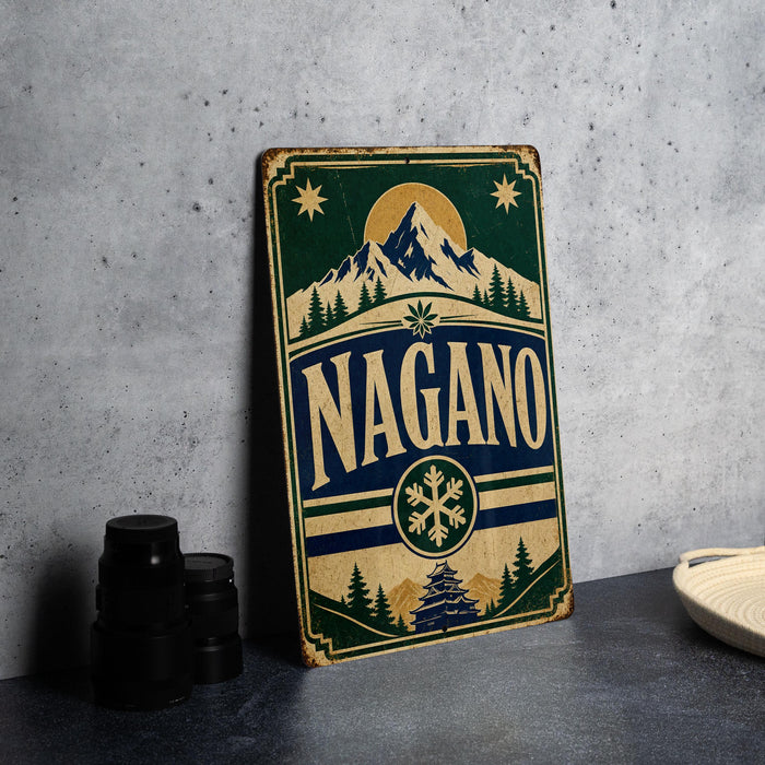A vintage-style sign with the word "NAGANO" prominently displayed, featuring a mountain landscape and snowflake design.