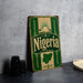 A vintage-style metal sign with the word "Nigeria" prominently displayed, featuring a map of the country and decorative elements.