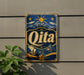 a vintage-style metal sign with a blue background and gold accents, hanging on a wall.
