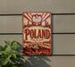 A vintage-style metal sign with the word "POLAND" prominently displayed, featuring a red and white color scheme and a depiction of Polish architecture and landmarks.