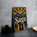 A vintage-style metal sign with the word "Saga" prominently displayed, featuring a sun and mountain design.