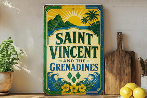 A vintage-style sign for Saint Vincent and the Grenadines, featuring a tropical landscape with palm trees and a sun. The sign is displayed on a shelf next to a wooden cutting board and a potted plant.