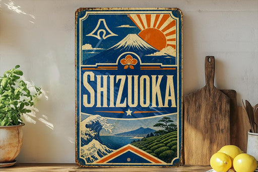 A vintage-style sign for Shizuka, a Japanese beverage, featuring a mountain, sun, and waves, along with the text "SHIZUOKA" prominently displayed.