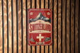 A vintage-style sign for Switzerland mounted on a wooden wall.