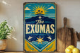 A vintage-style sign with a tropical beach scene and the text "The EXUMAS" is displayed on a shelf next to a wooden cutting board and some lemons.