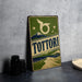 A vintage-style metal sign with the word "TOTTORI" prominently displayed, featuring a mountain landscape and a bird silhouette.