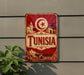 a sign with the word "TUNISIA" prominently displayed, along with a crescent moon and star symbol, indicating the country of Tunisia.