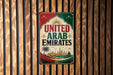 A vintage-style sign that reads "UNITED ARAB EMIRATES" with a palm tree and a city skyline in the background.