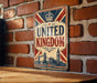 A vintage-style sign that reads "UNITED KINGDOM" is displayed on a brick wall.