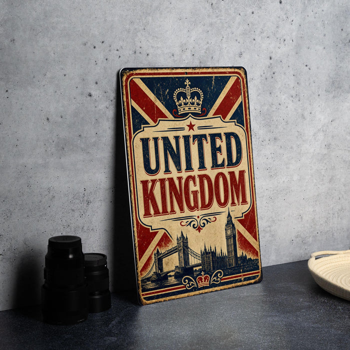 A vintage-style metal sign with the text "UNITED KINGDOM" prominently displayed, featuring a British flag design and a crown. The sign is placed on a gray countertop, with a stack of black camera lenses and a white dish visible to the side.