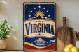 a vintage-style sign with the word "VIRGINIA" prominently displayed, along with a sun and mountain motif. The sign is placed on a shelf next to a wooden cutting board and a potted plant, creating a patriotic and homey atmosphere.