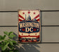 A vintage-style sign with the text "WASHINGTON DC" prominently displayed, featuring the iconic Washington Monument and other landmarks in the background.