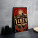 A vintage-style poster or sign with the word "YEMEN" prominently displayed, featuring a cityscape and a sun-like symbol.