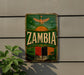 a vintage-style sign with the word "Zambia" prominently displayed, along with a colorful illustration of a tropical landscape and a bird.