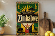 A vintage Zimbabwe-themed metal sign with a sun and landscape design, featuring the word "Zimbabwe" prominently displayed.
