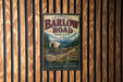 A vintage metal sign for the historic Barlow Road in Oregon, featuring an illustration of a wagon train on a scenic trail surrounded by mountains.
