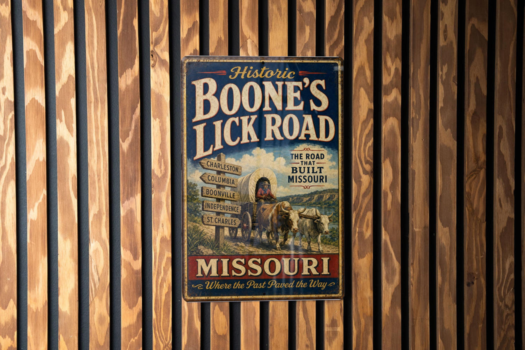 A vintage metal sign advertising "Boone's Lick Road" in Missouri, featuring a wagon and a sign with directions to various locations.