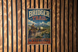 A vintage metal sign for the Bridger Trail in Wyoming, featuring a cowboy on horseback and the trail's name.
