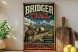 A vintage-style metal sign for the Bridger Trail in Wyoming, featuring a cowboy on horseback and a wagon, with the text "Bridger Trail" and "Est. 1863" prominently displayed.