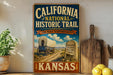 A vintage-style sign for the California National Historic Trail, featuring an illustration of a wagon train on a dirt road and a monument, with the text "California National Historic Trail" and "The road to opportunity" prominently displayed.