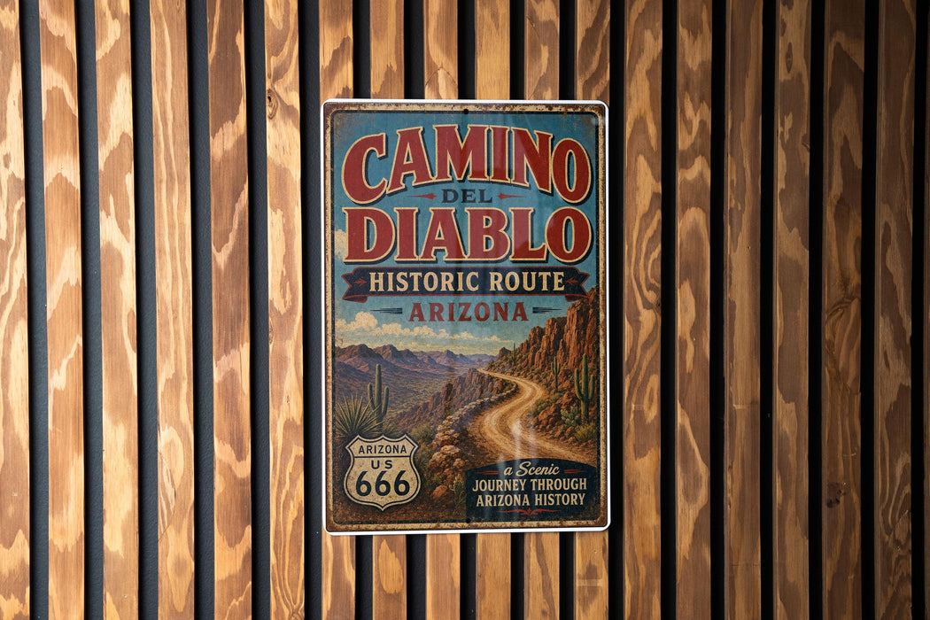 A vintage-style metal sign for the Camino del Diablo Historic Route in Arizona, featuring a desert landscape with mountains and a road.
