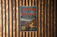 A vintage-style metal sign for the Camino del Diablo Historic Route in Arizona, featuring a desert landscape with mountains and a road.