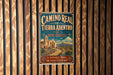 A vintage-style metal sign for the Camino Real de Tierra Adentro trail in New Mexico, featuring a historical trail and a desert landscape.