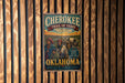 A vintage metal sign with the title "CHEROKEE TRAIL OF TEARS" hangs on a wooden wall.