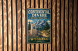 A metal sign with the text "Continental Divide National Scenic Trail Wyoming" is displayed on a wooden wall.
