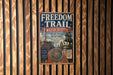 a metal sign with a vintage design, mounted on a wooden wall.