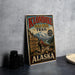 A vintage-style poster advertising Klondike Gold Rush Trail in Alaska, featuring a man hiking along a trail with mountains in the background.
