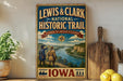 A vintage-style metal sign for Lewis & Clark National Historic Trail, featuring illustrations of two hikers and a scenic landscape.
