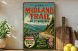 a vintage-style sign for the "Midland Trail" in West Virginia, with a scenic mountain landscape and a bridge in the background.
