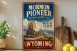 A vintage-style sign for the Mormon Pioneer National Historic Trail in Wyoming, featuring an illustration of a wagon train traveling through the state.