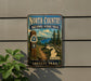 a vintage-style metal sign for the North Country National Scenic Trail, mounted on a wall next to a plant.