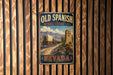 A vintage-style metal sign for the Old Spanish National Historic Trail in Nevada, featuring a wagon train and a cross on a dirt road.
