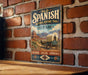 A vintage-style metal sign for the Old Spanish National Historic Trail in Utah, featuring a wagon train and a desert landscape.
