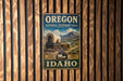 A vintage-style metal sign for the Oregon National Historic Trail in Idaho, featuring a wagon and a scenic landscape.