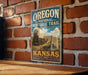 A vintage-style sign for the Oregon National Historic Trail in Kansas, featuring an illustration of a covered wagon and a sign that says "Oregon National Historic Trail Kansas".