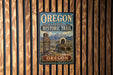 A vintage-style sign for the Oregon National Historic Trail, featuring a wagon train and mountains in the background.