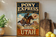 A vintage-style metal sign for Pony Express National Historic Trail, featuring a cowboy riding a horse and the text "Where courage carried the mail to Utah".