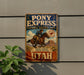 A vintage-style metal sign for Pony Express National Historic Trail, featuring a cowboy riding a horse and the text "Where courage carried the mail" and "UTAH".