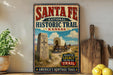a vintage-style sign for the Santa Fe National Historic Trail in Kansas, with a wagon train and a stone marker in the foreground.