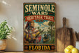 a vintage-style sign for the Florida Heritage Trail, with a painting of a Native American man holding a rifle and a canoe in a river. The sign is displayed on a shelf next to a wooden cutting board and a potted plant.