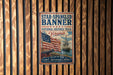 a vintage-style metal sign with an American flag and a ship, mounted on a wooden wall.