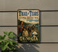 A vintage trail sign for the Trail of Tears, which is a National Historic Trail in Georgia. The sign features an illustration of a group of people, including Native Americans, traveling along the trail.