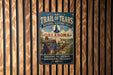 A vintage-style metal sign for the Trail of Tears, a significant historical event in Oklahoma, with a cowboy and wagon train illustration.