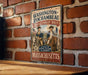 A vintage metal sign on a brick wall, featuring two men in military uniforms and the text "Washington-Rochambeau Revolutionary Route" and "Massachusetts".
