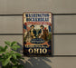 a vintage-style sign with a historical theme, mounted on a wall next to a plant.